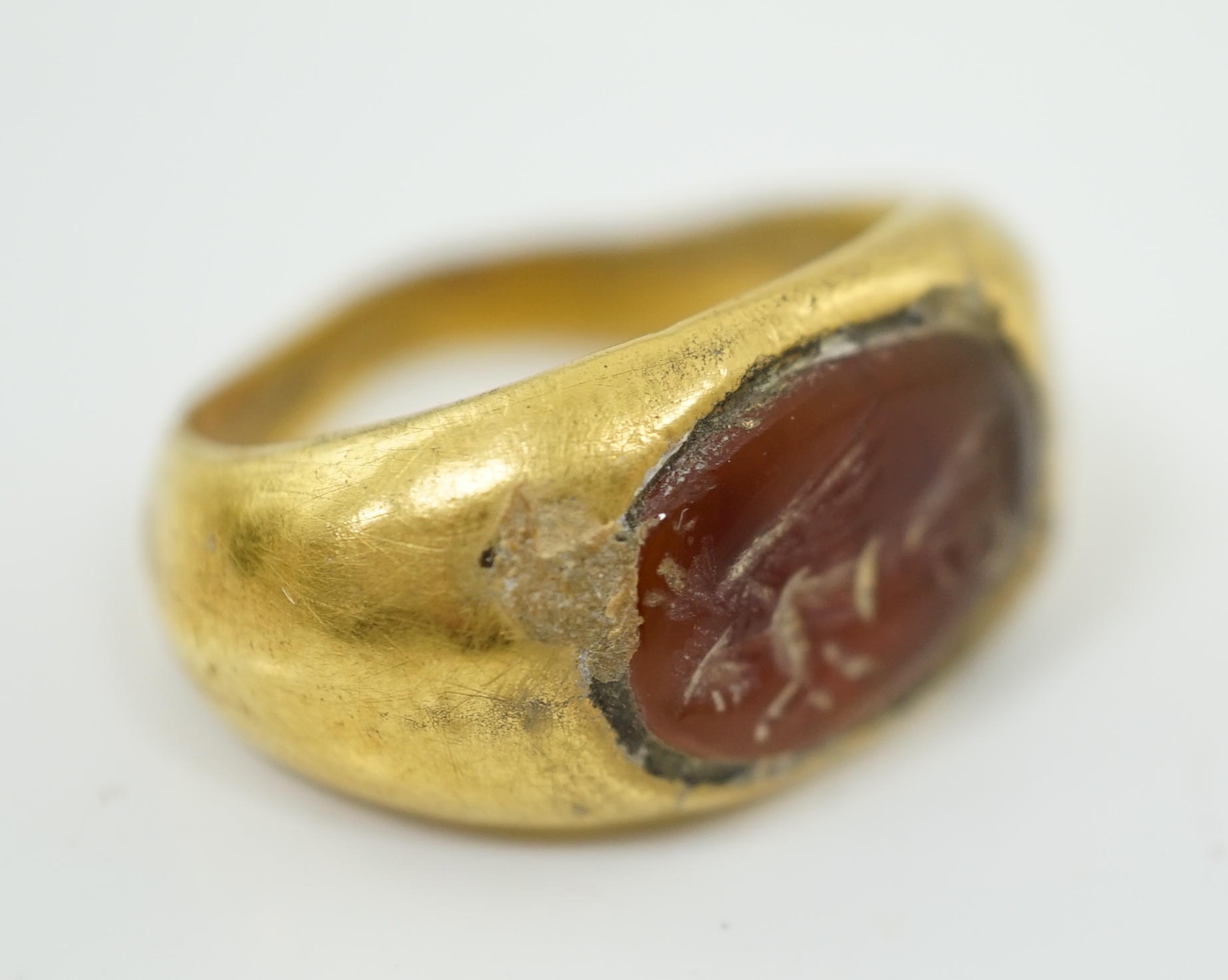 A Greco-Roman gold and intaglio carnelian set finger ring, carved with the figure of Nike, circa 1st century B.C.